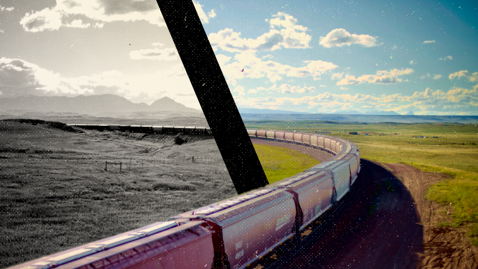 An extremely long freight train curving into the distance in the open country of Montana with mountains in the distance.