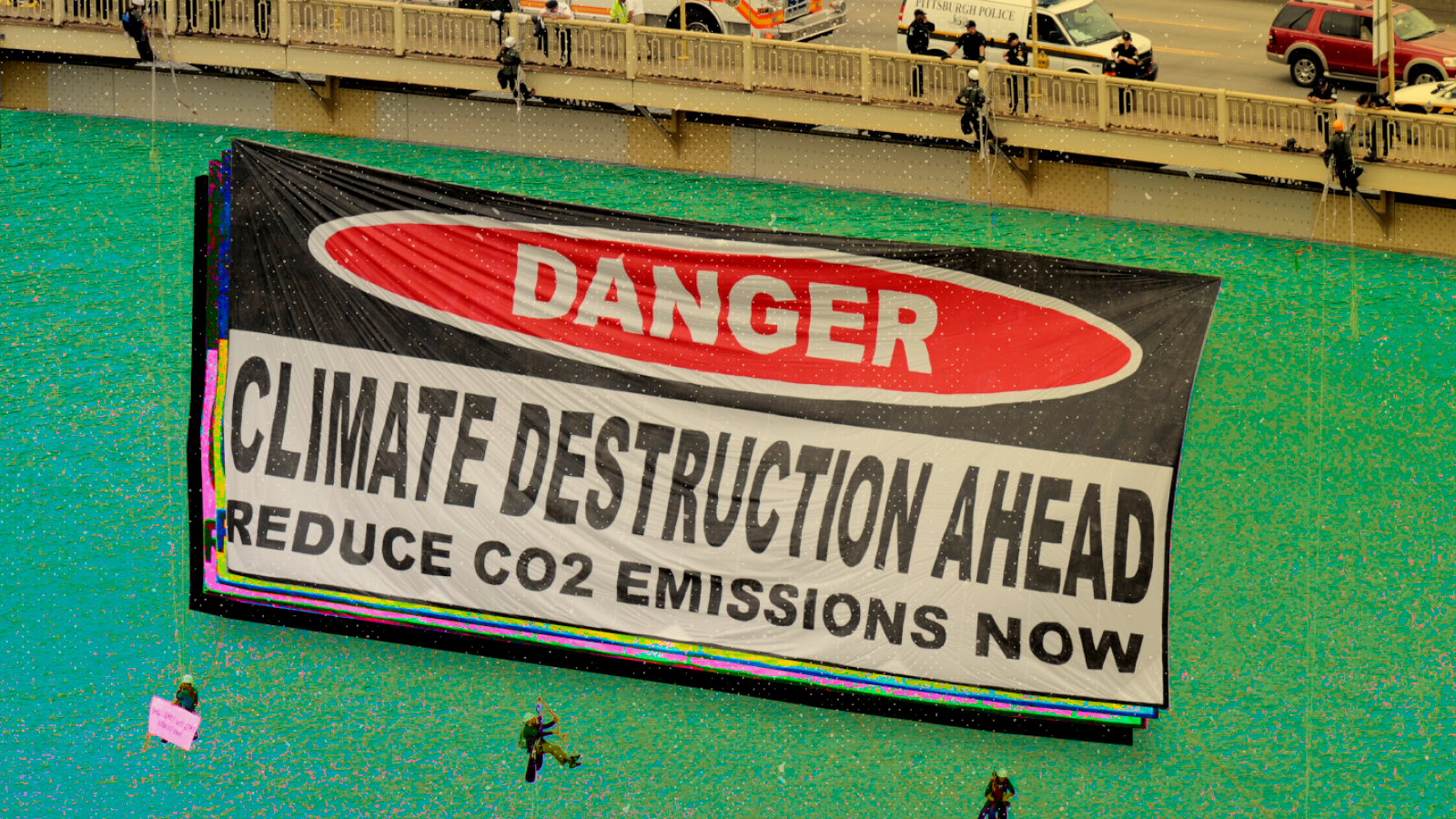 Climate protesters hang a sign from the West End Bridge over the Ohio River. (AP Photo/Don Wright)