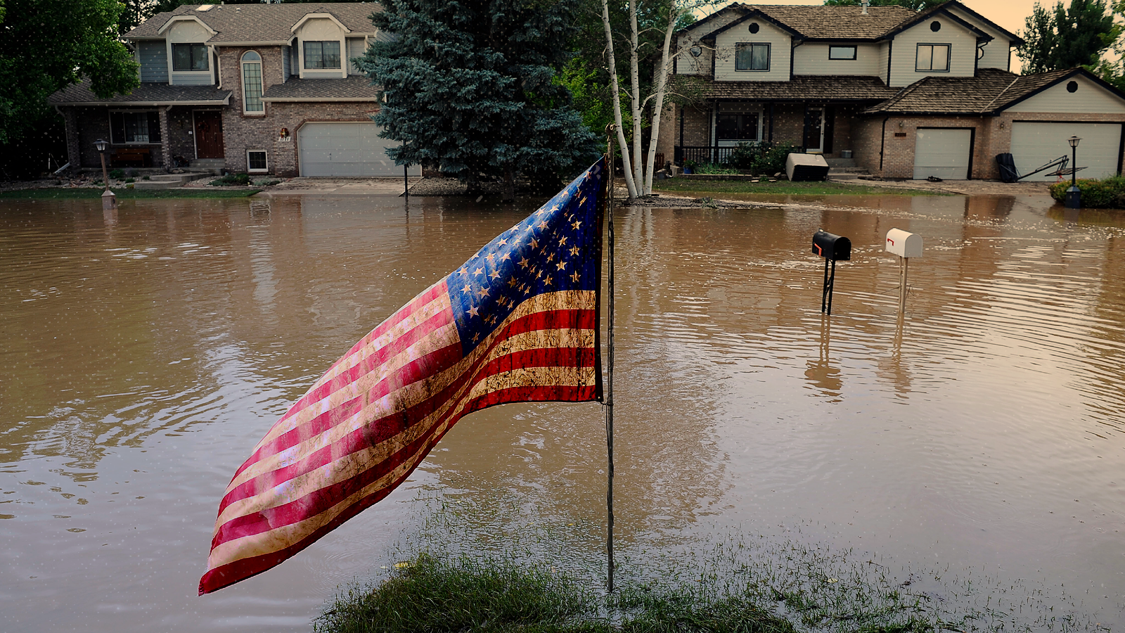 A muddy U.S. flag stands in front of flooded homes in Longmont, Colorado, after a flood in 2013.