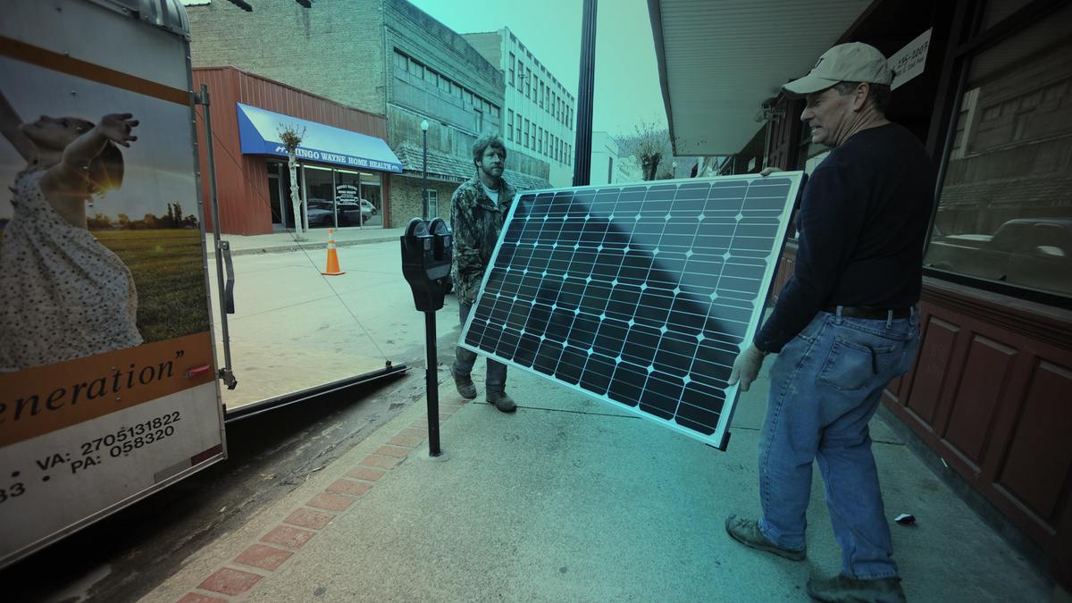 Evell Meade, left, and Mitch Mitchell carry a solar panel into a doctor’s office in Williamson, W.Va. (AP Photo/Jeff Gentner)