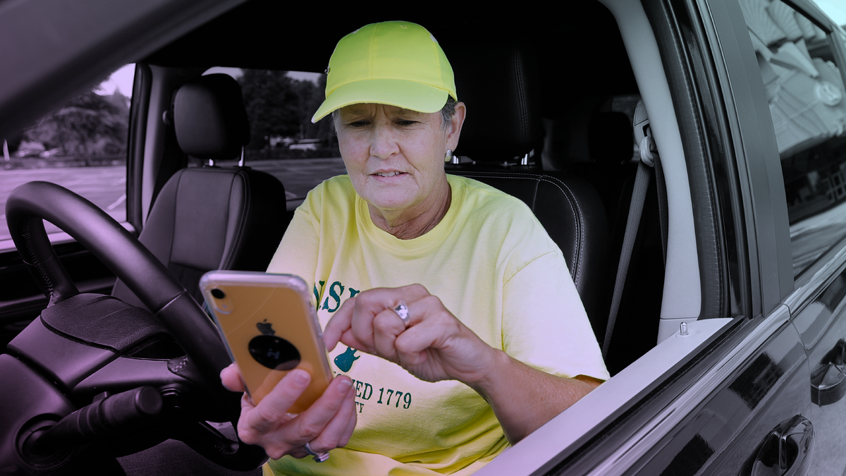 Lyft driver Joni Bicknese checks her phone app between riders. (AP Photo/Mark Humphrey)