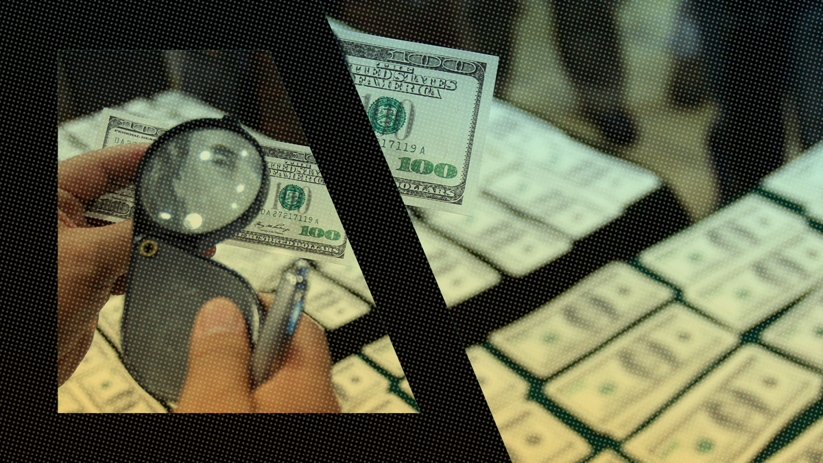 A person inspects an alleged counterfeit $100 U.S. dollar bill. (AP Photo/Karel Navarro)