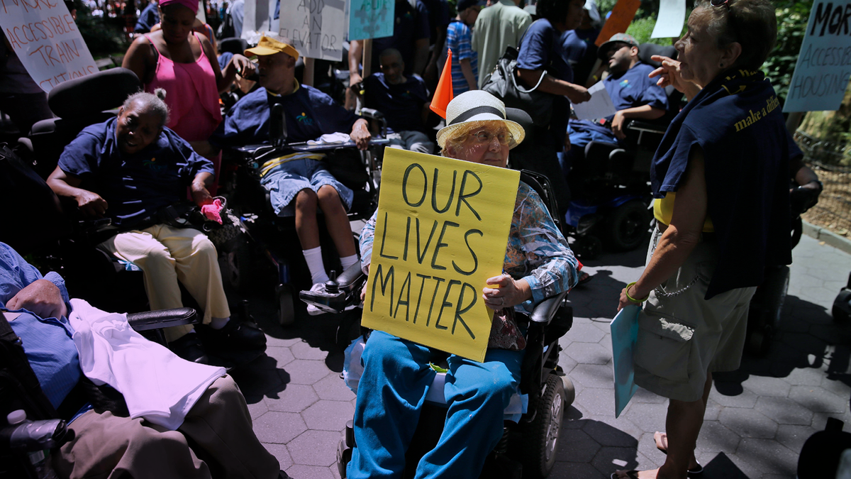 Anita Cantor, of Brooklyn, New York, holds a sign at the Disability Pride Parade in New York in 2015. (AP Photo/Seth Wenig)