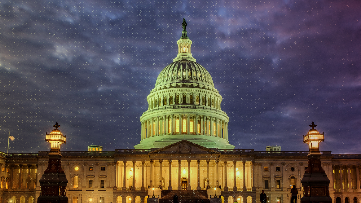 Lights shine inside the U.S. Capitol Building with heavy clouds above as night falls in Washington. (AP Photo/J. David Ake)