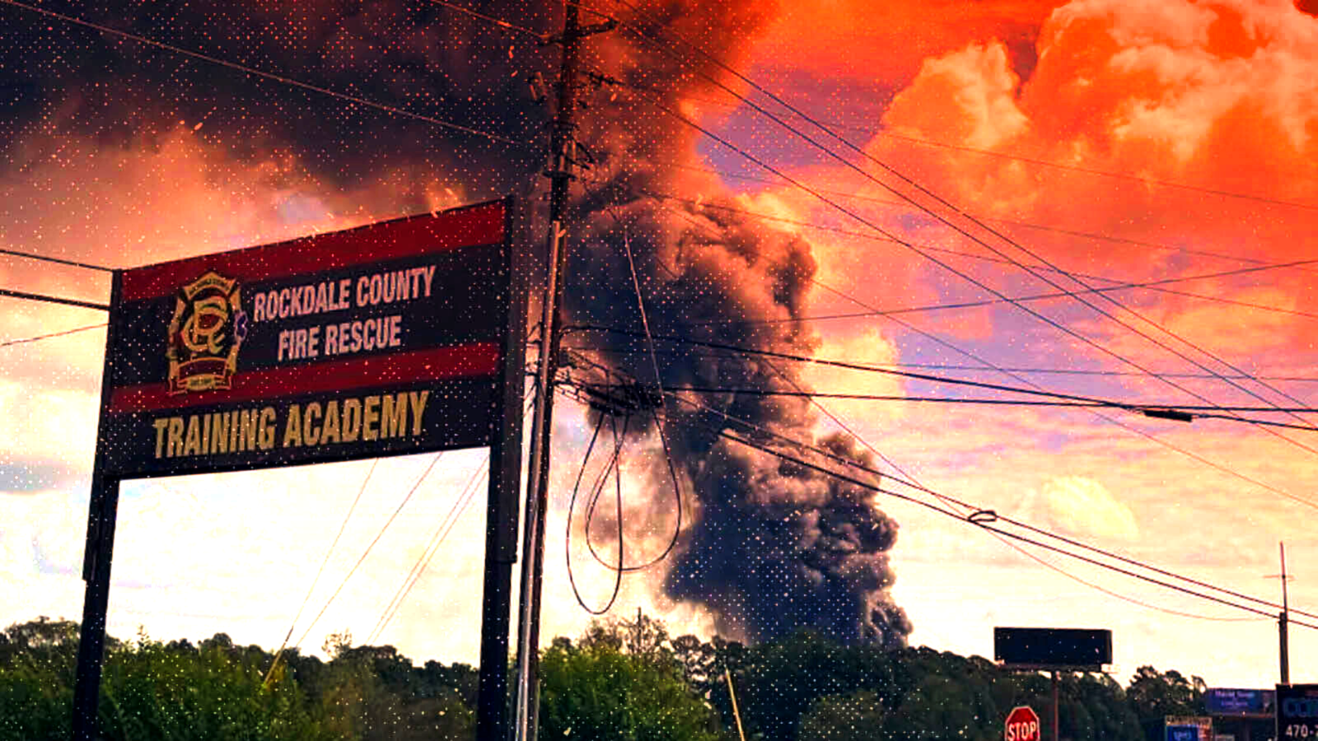 A massive plume of smoke is seen behind a Rockdale County Fire Rescue sign